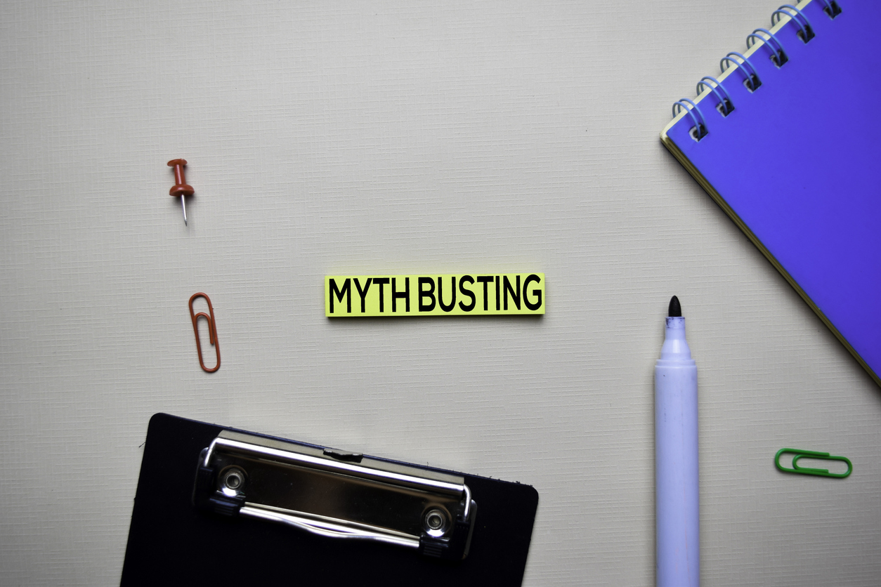 Myht Busting text on sticky notes with office desk concept