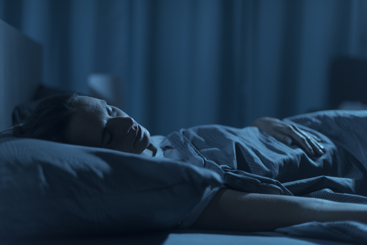 Woman getting healthy sleep in her bed at night.