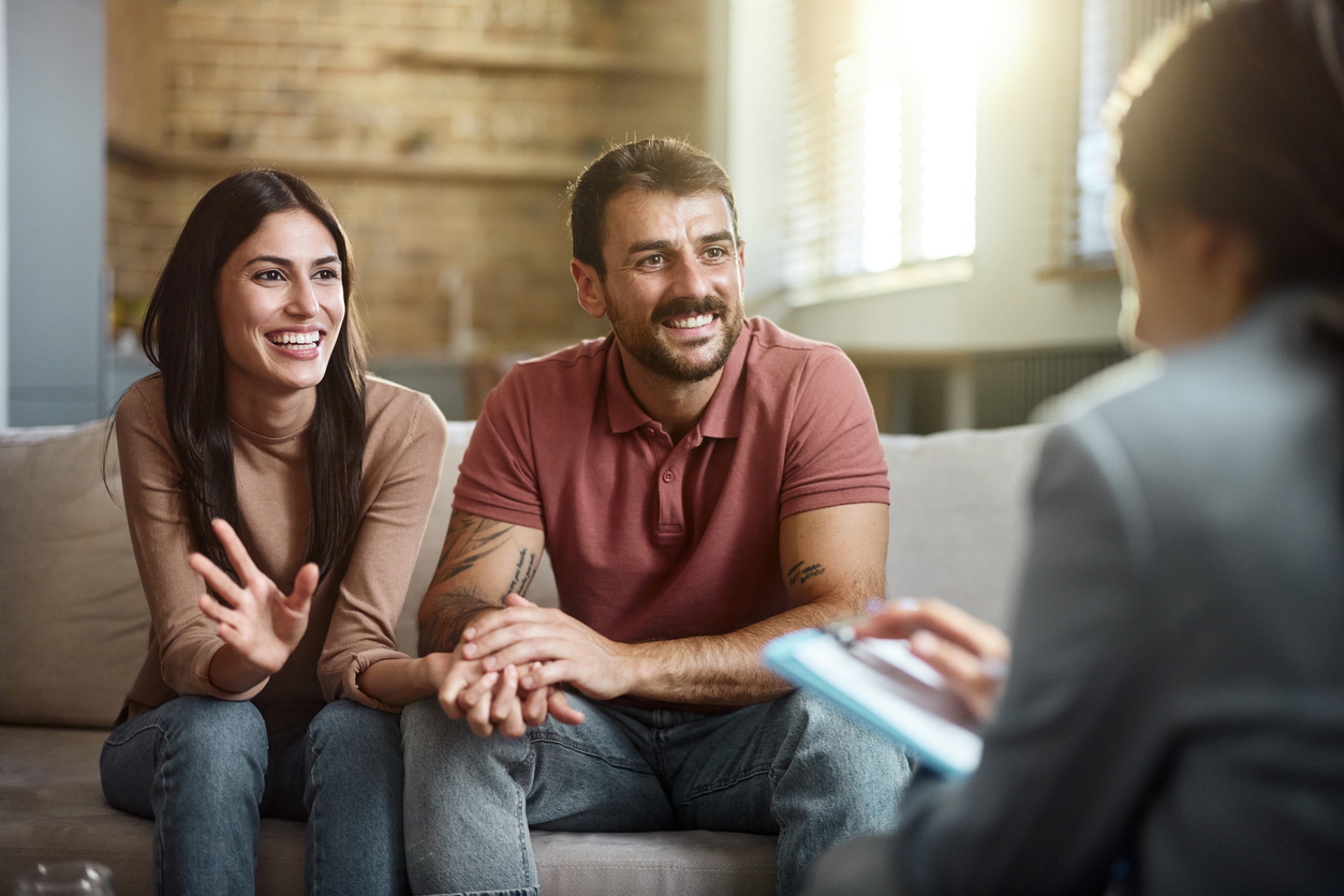 Happy couple having a counseling session with therapist.